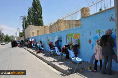 دست های کوچک اعضای کانون پرورش فکری کودک و نوجوان در زیباسازی دیوار بیرونی پردیس بنت الهدی صدر