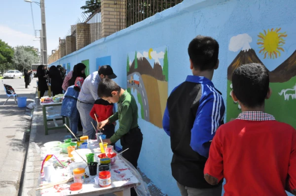 دست های کوچک اعضای کانون پرورش فکری کودک و نوجوان در زیباسازی دیوار بیرونی پردیس